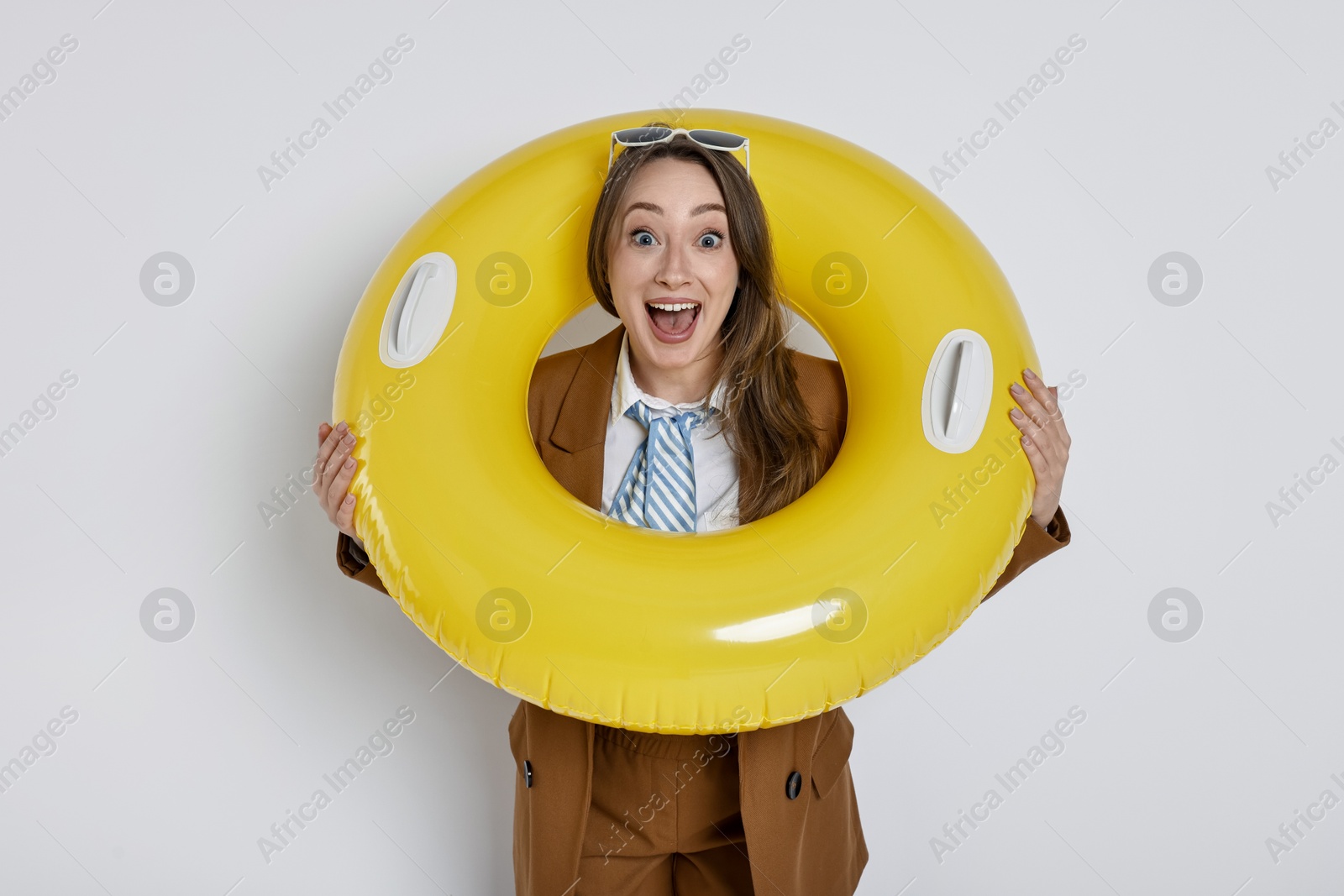 Photo of Businesswoman with inflatable ring and sunglasses on white background