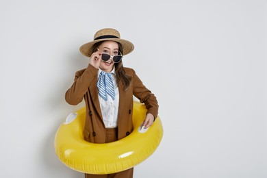 Photo of Businesswoman with inflatable ring, straw hat and sunglasses on white background, space for text