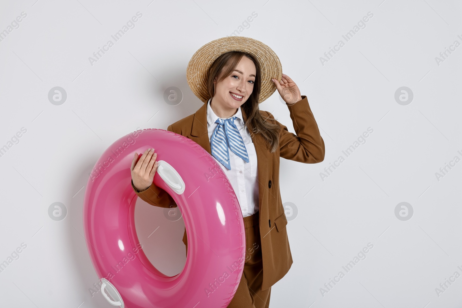 Photo of Businesswoman with inflatable ring and straw hat on white background