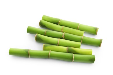 Photo of Cut green bamboo stems isolated on white, top view