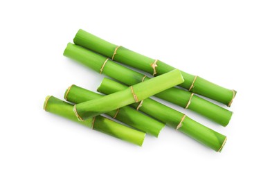 Photo of Cut green bamboo stems isolated on white, top view