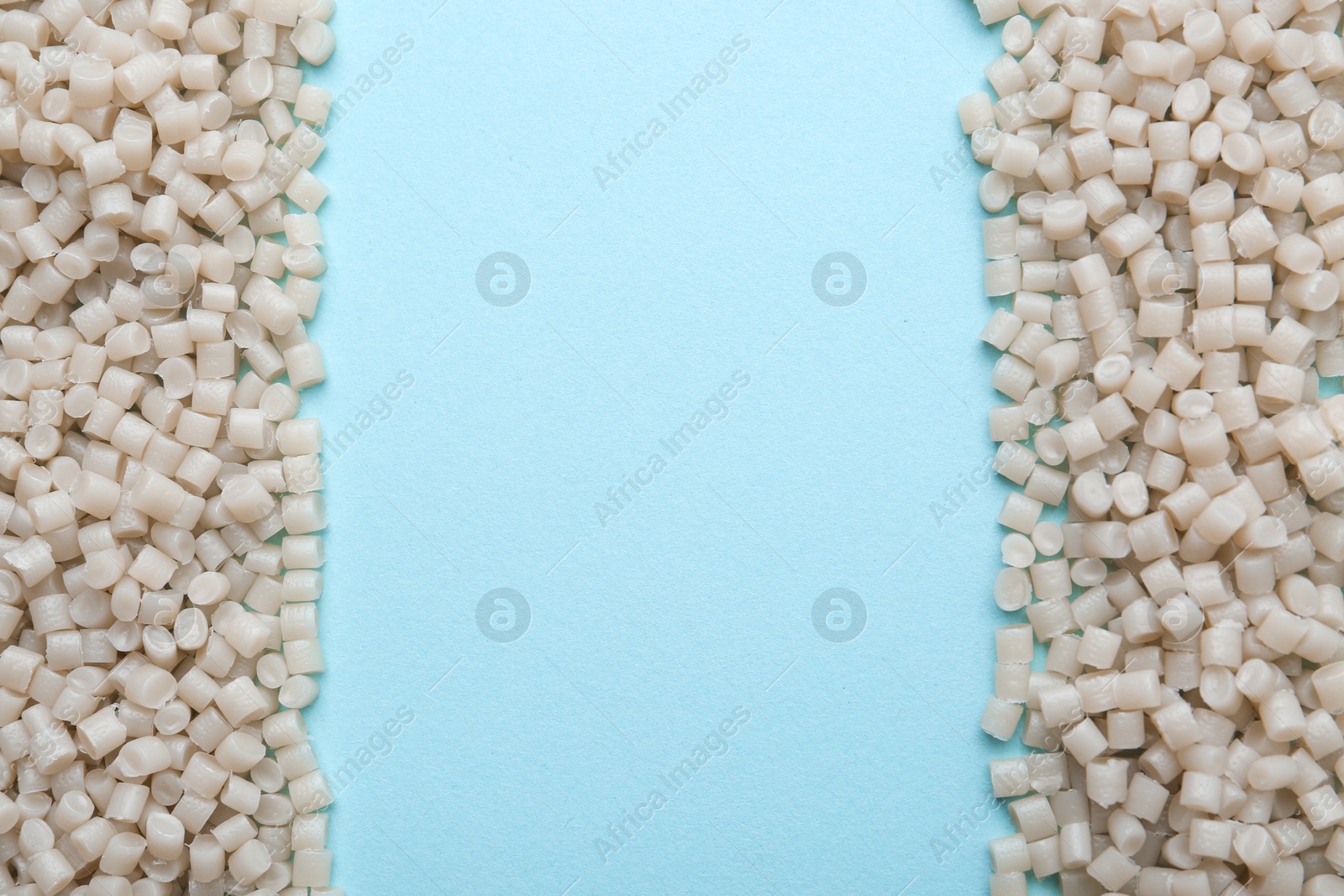 Photo of Pile of plastic granules on light blue background, top view. Space for text