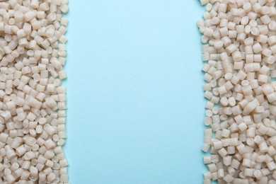 Photo of Pile of plastic granules on light blue background, top view. Space for text