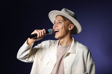 Talented young man singing on dark background