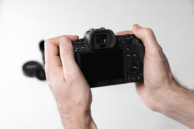 Photo of Photographer taking photo with professional camera on white background, closeup