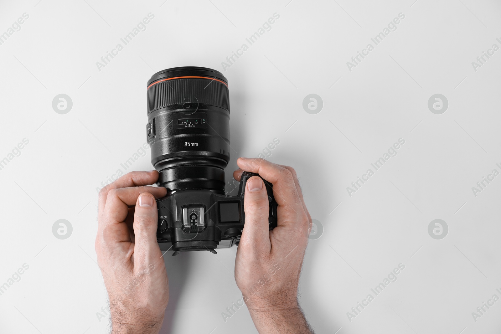 Photo of Photographer with professional camera on white background, top view. Space for text