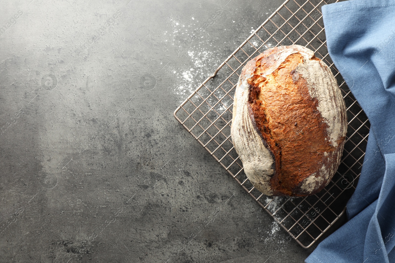 Photo of Freshly baked bread on grey table, top view. Space for text