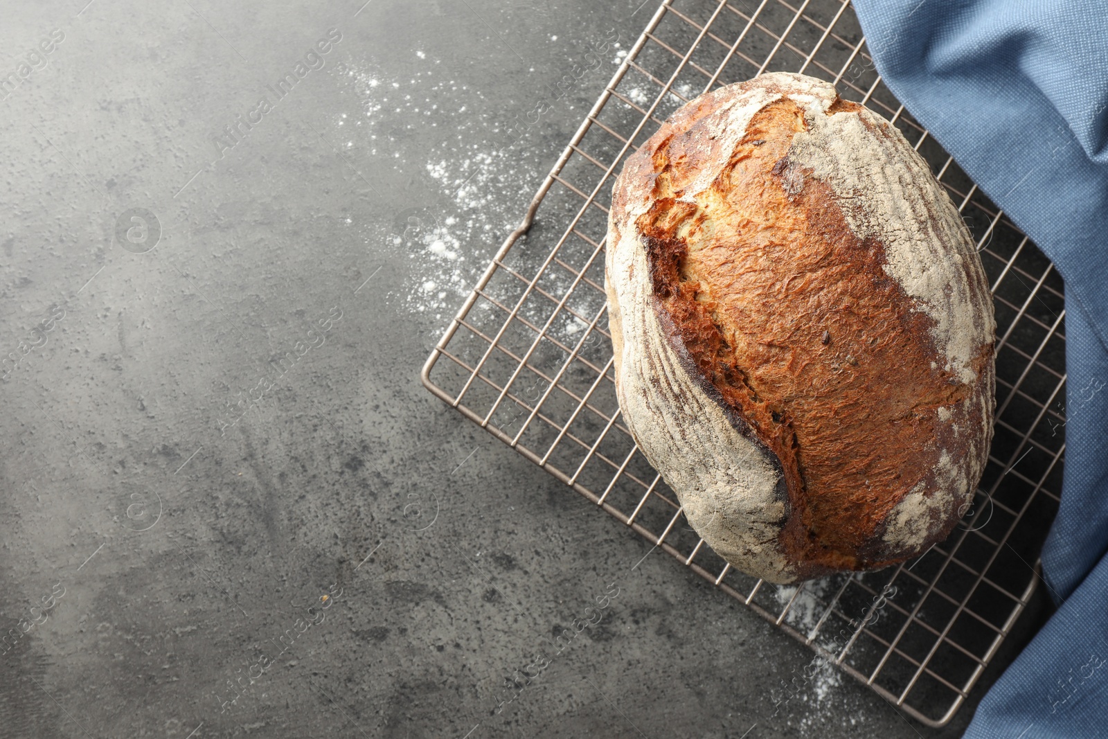 Photo of Freshly baked bread on grey table, top view. Space for text