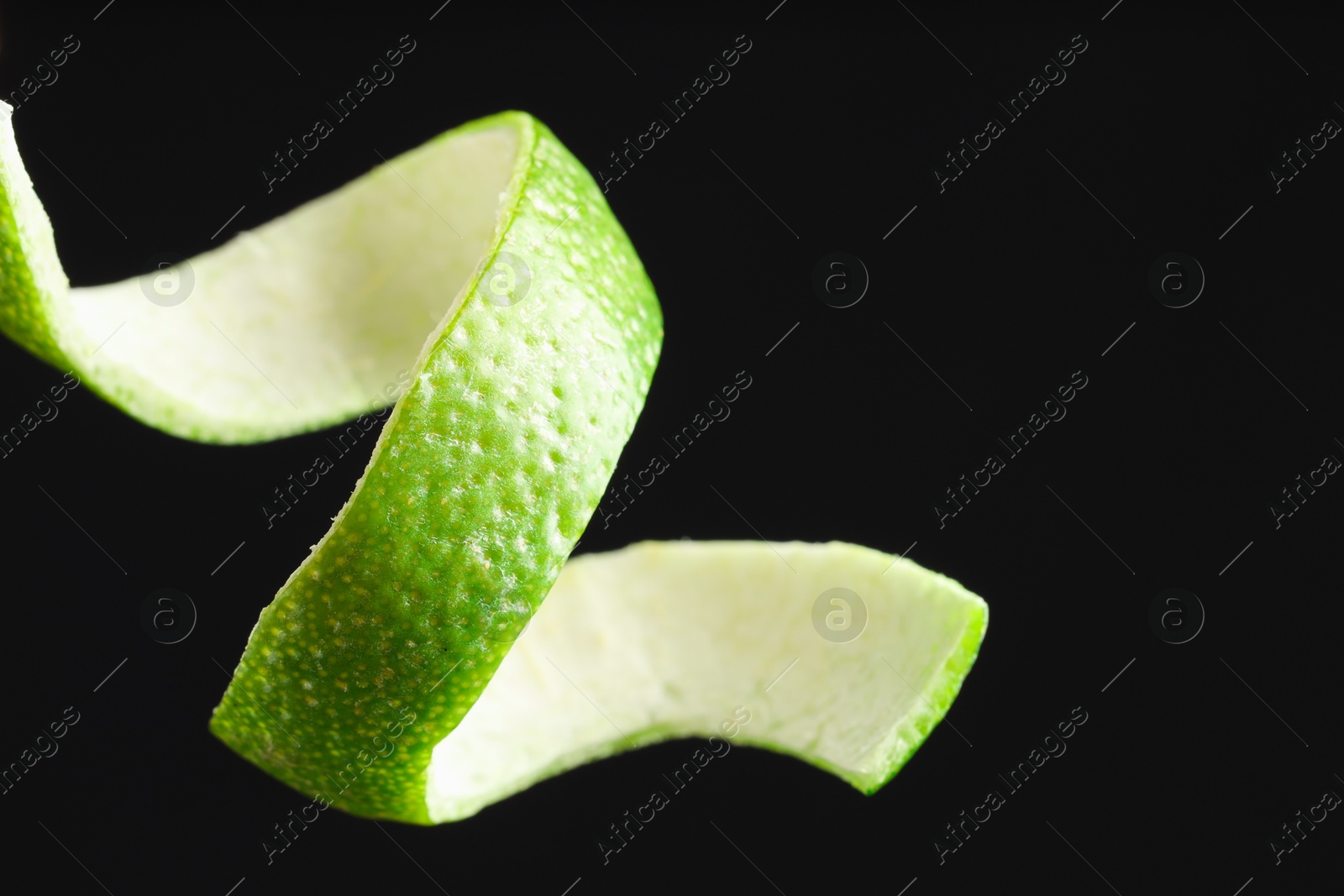 Photo of Fresh lime peel on black background, closeup