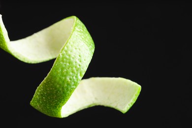 Photo of Fresh lime peel on black background, closeup