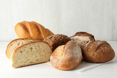 Photo of Whole and cut bread loafs on white table