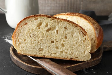 Photo of Pieces of fresh bread on black table, closeup