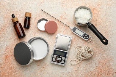 Photo of Soy wax, essential oils and different tools for making candles on beige textured table, flat lay