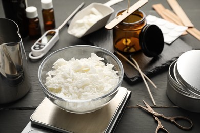 Photo of Soy wax, essential oils and different tools for making candles on grey wooden table, closeup