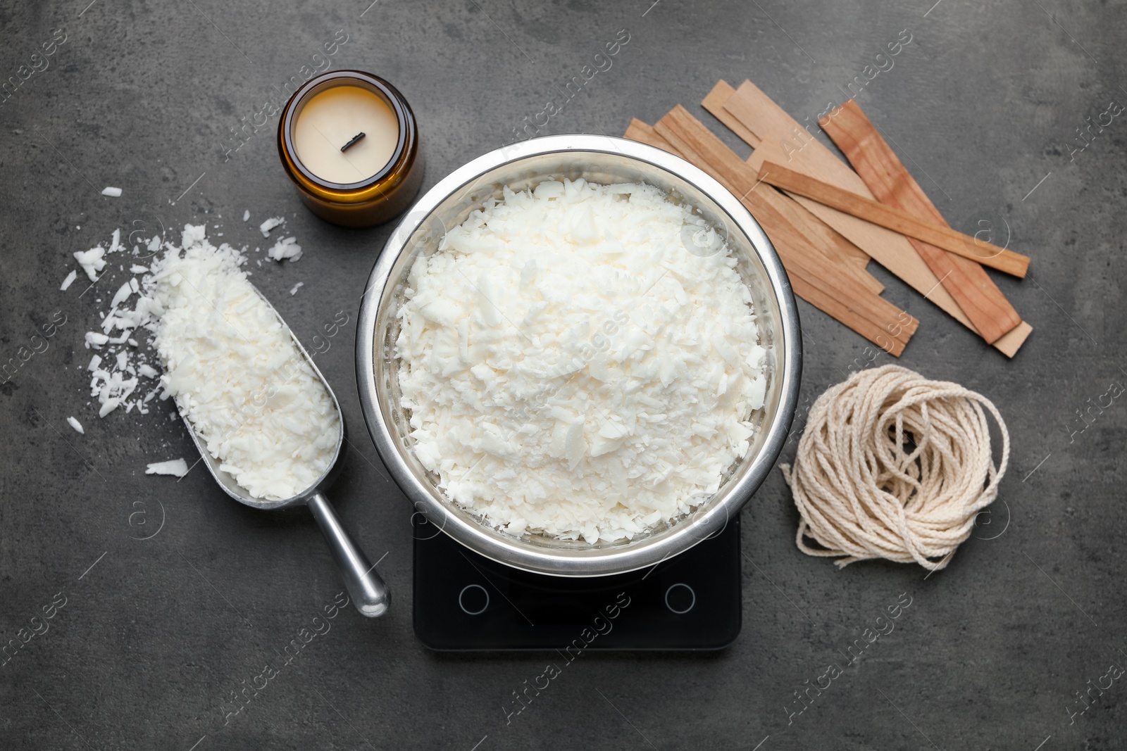 Photo of Soy wax and other supplies for making candles on grey table, flat lay