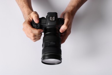 Photo of Photographer with professional camera on light background, above view