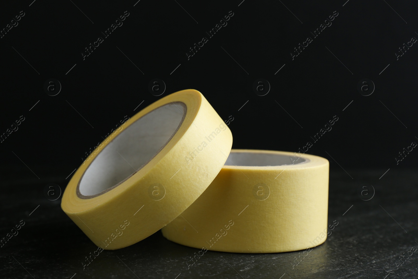 Photo of Rolls of masking tape on black table, closeup