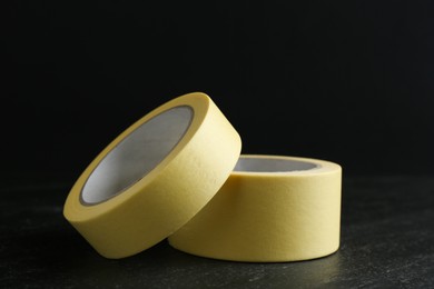 Photo of Rolls of masking tape on black table, closeup