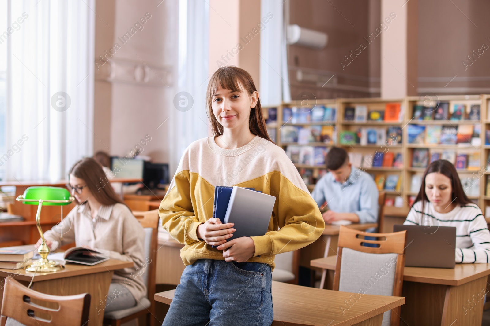 Photo of Portrait of beautiful woman with books in library