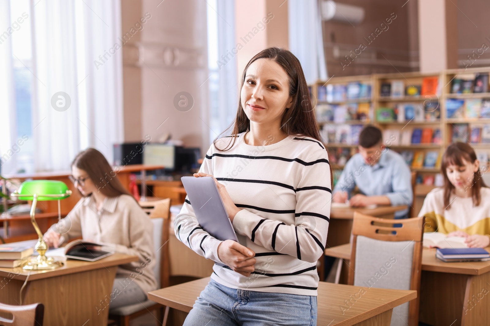 Photo of Portrait of beautiful woman with laptop in library