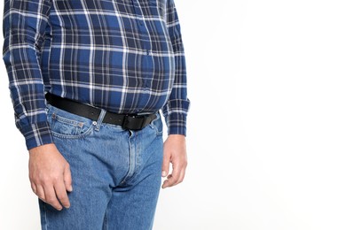 Photo of Overweight man in tight shirt on white background, closeup. Space for text