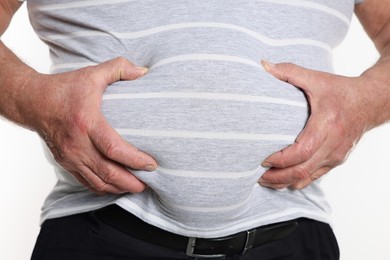 Photo of Overweight man in tight t-shirt on white background, closeup