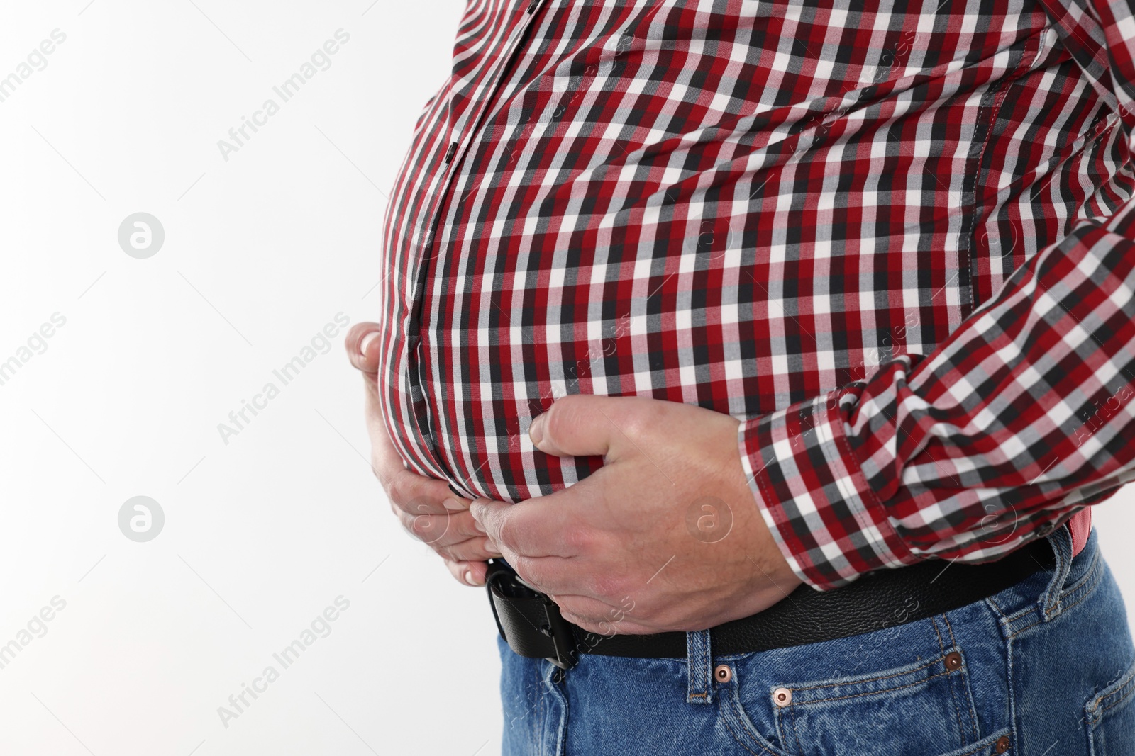 Photo of Overweight man in tight shirt on white background, closeup. Space for text