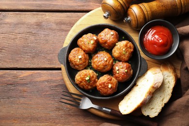 Photo of Tasty meatballs in baking dish served on wooden table, flat lay. Space for text