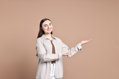 Happy woman welcoming friends or guests on beige background