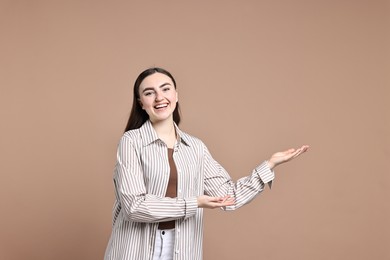 Photo of Happy woman welcoming friends or guests on beige background