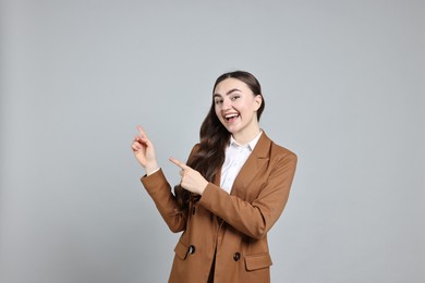 Photo of Happy businesswoman welcoming clients or partners on grey background