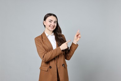 Photo of Happy businesswoman welcoming clients or partners on grey background