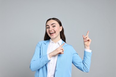 Photo of Happy businesswoman welcoming clients or partners on grey background