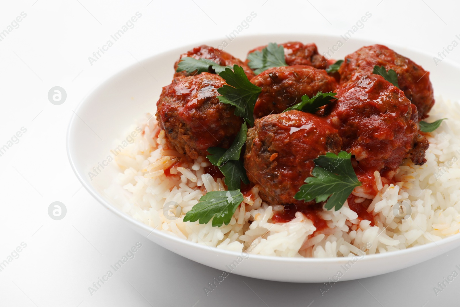 Photo of Delicious meatballs with rice, sauce and parsley on white background, closeup