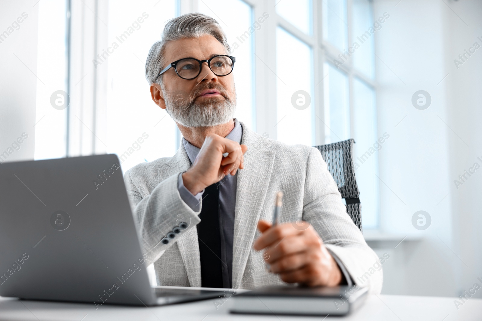 Photo of Banker with glasses at desk in office