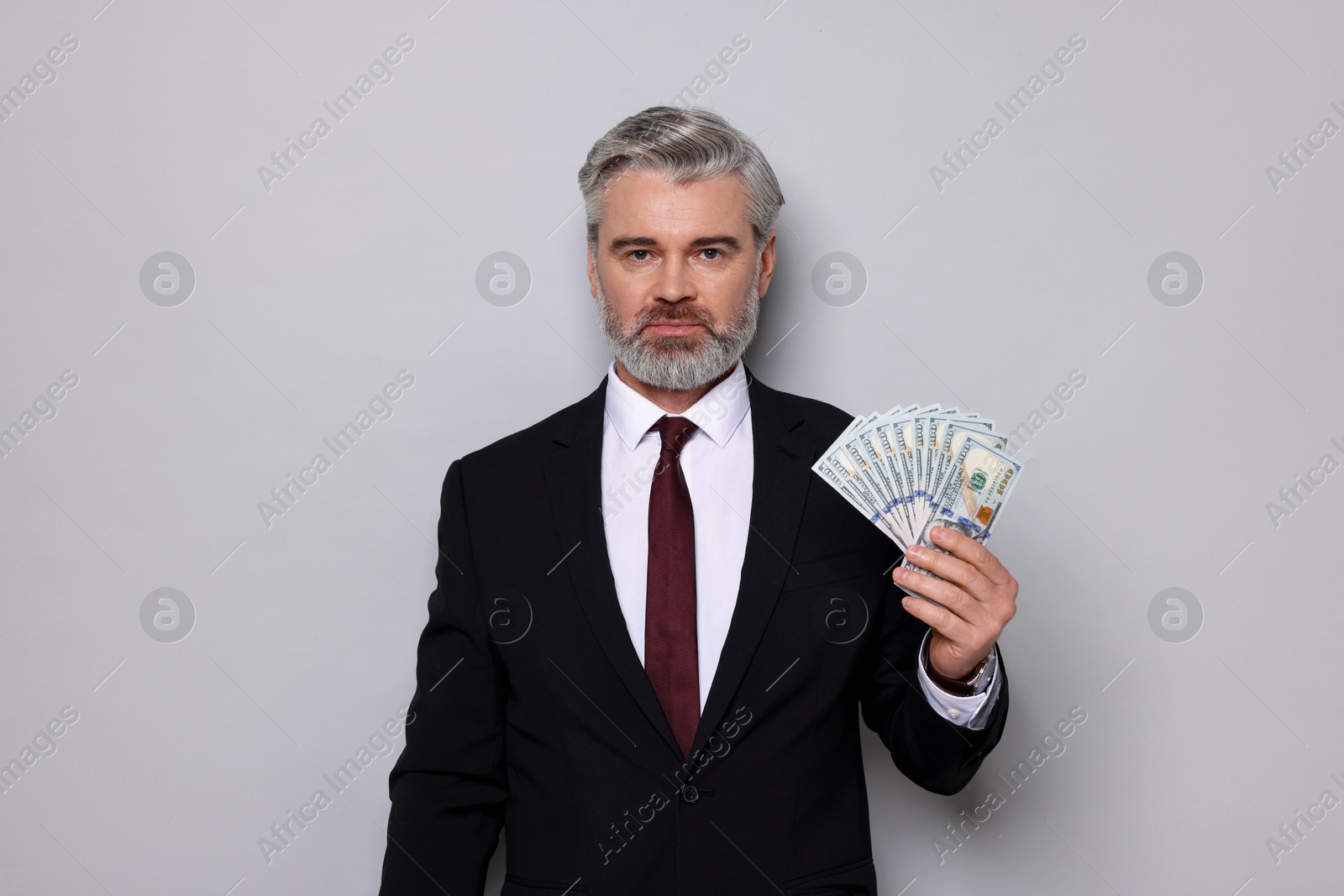 Photo of Banker with dollar banknotes on grey background