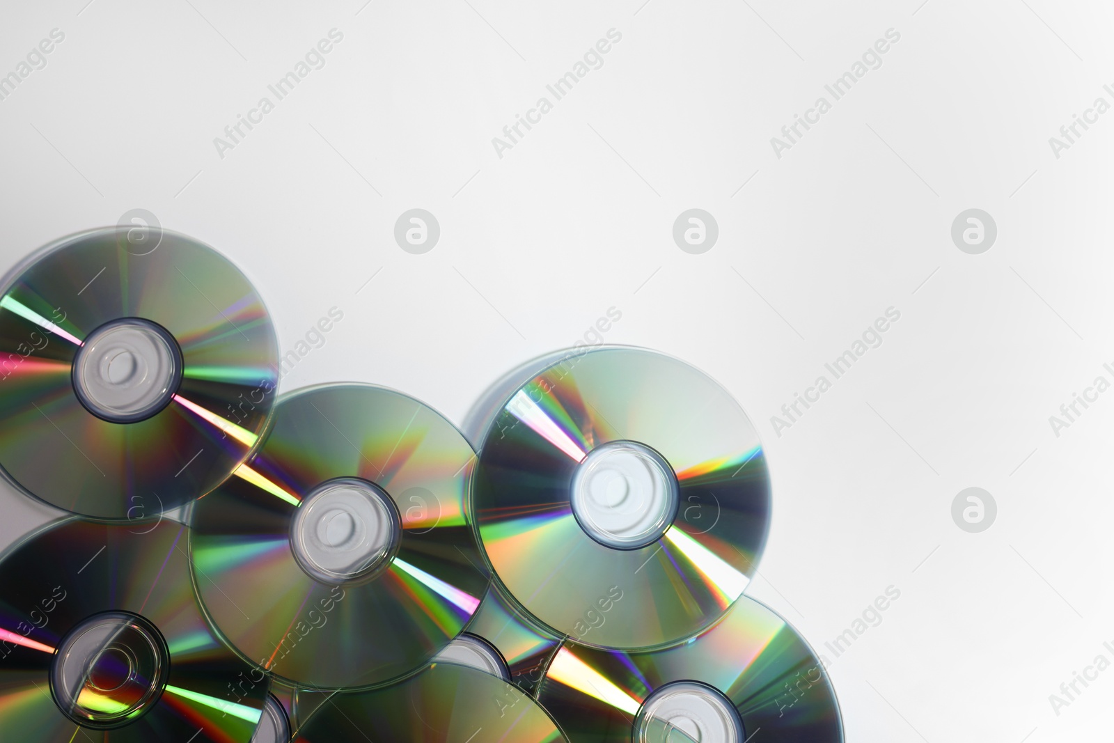 Photo of Many shiny compact discs on dusty blue background, flat lay. Space for text