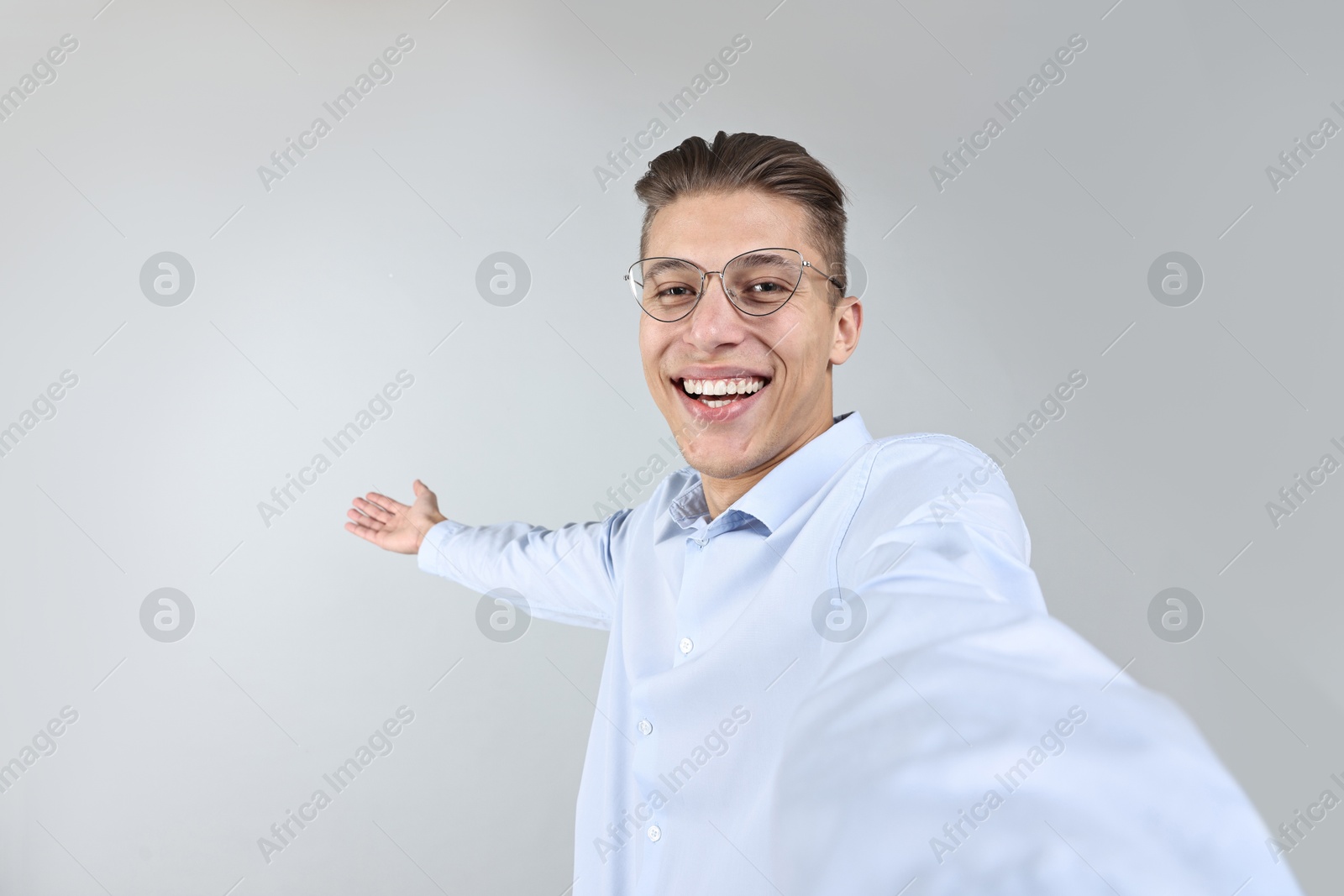 Photo of Happy businessman taking selfie and welcoming clients or partners on grey background. Space for text