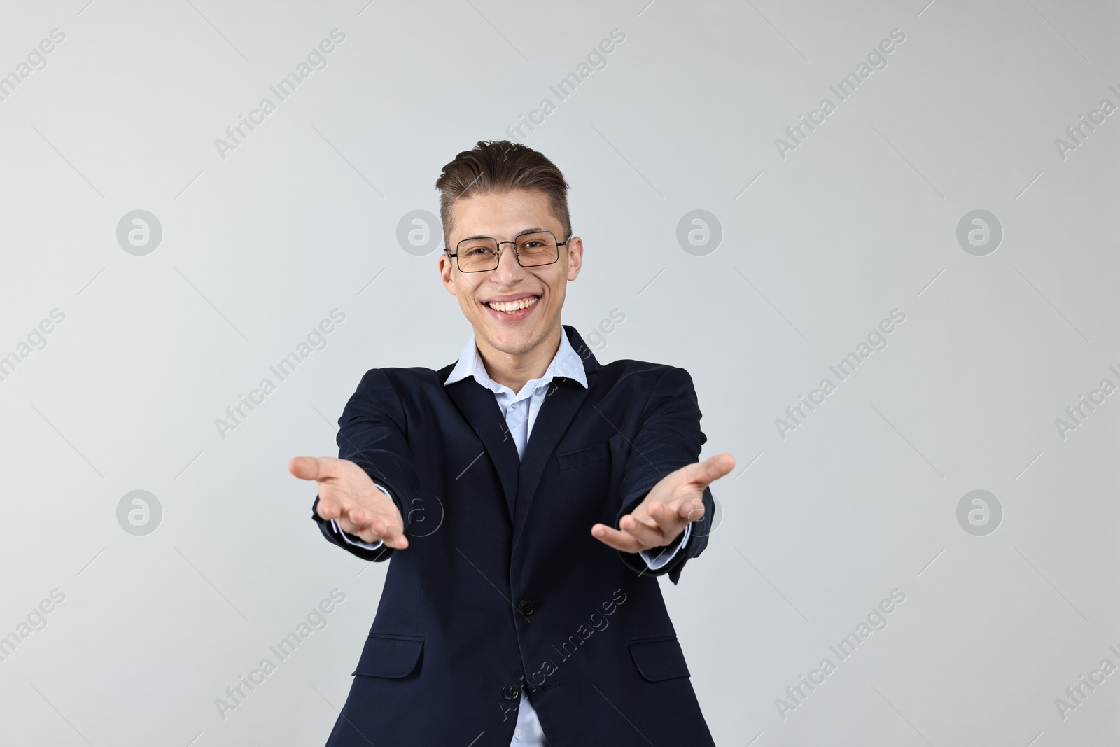 Photo of Happy businessman welcoming clients or partners on grey background