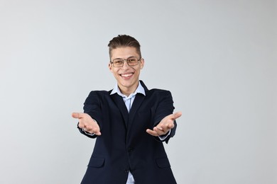 Photo of Happy businessman welcoming clients or partners on grey background