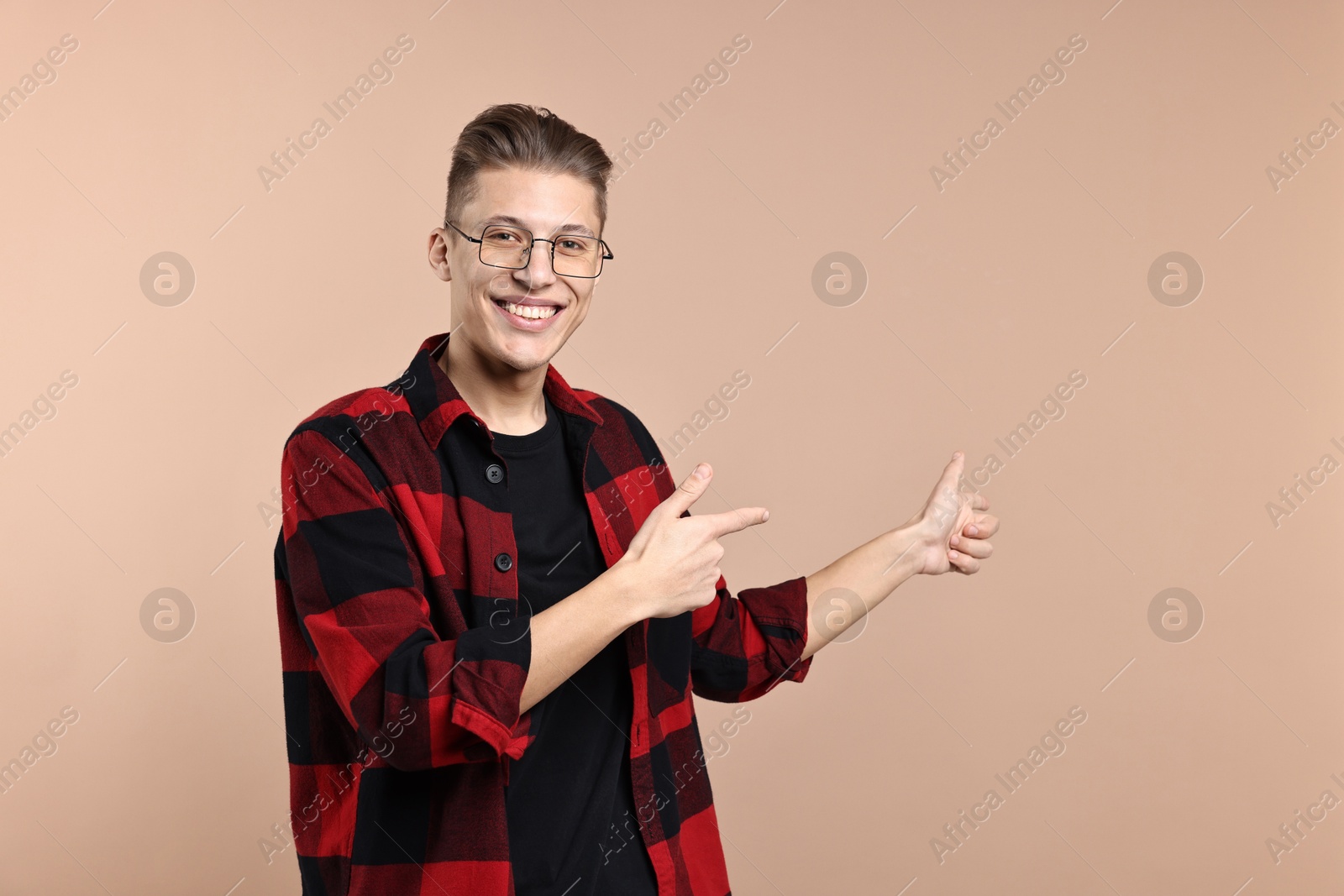 Photo of Happy man welcoming friends or guests on beige background. Space for text