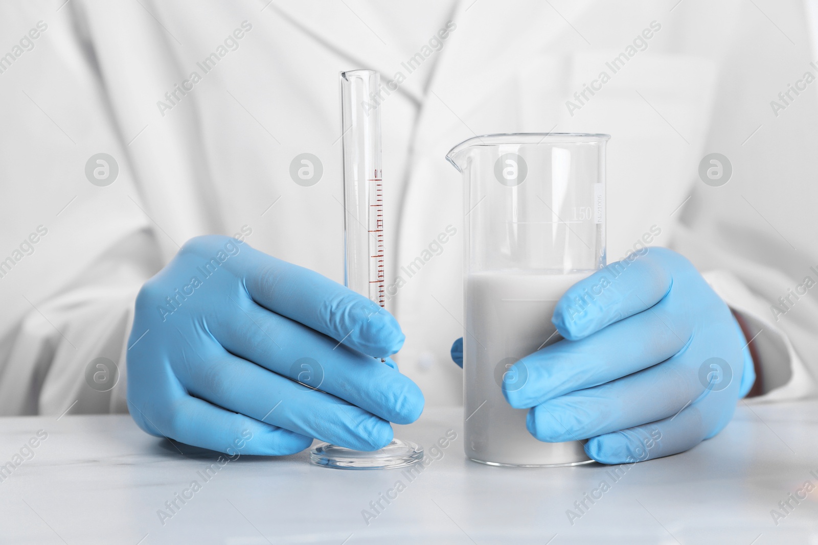 Photo of Laboratory testing. Scientist working with glassware at white marble table, closeup