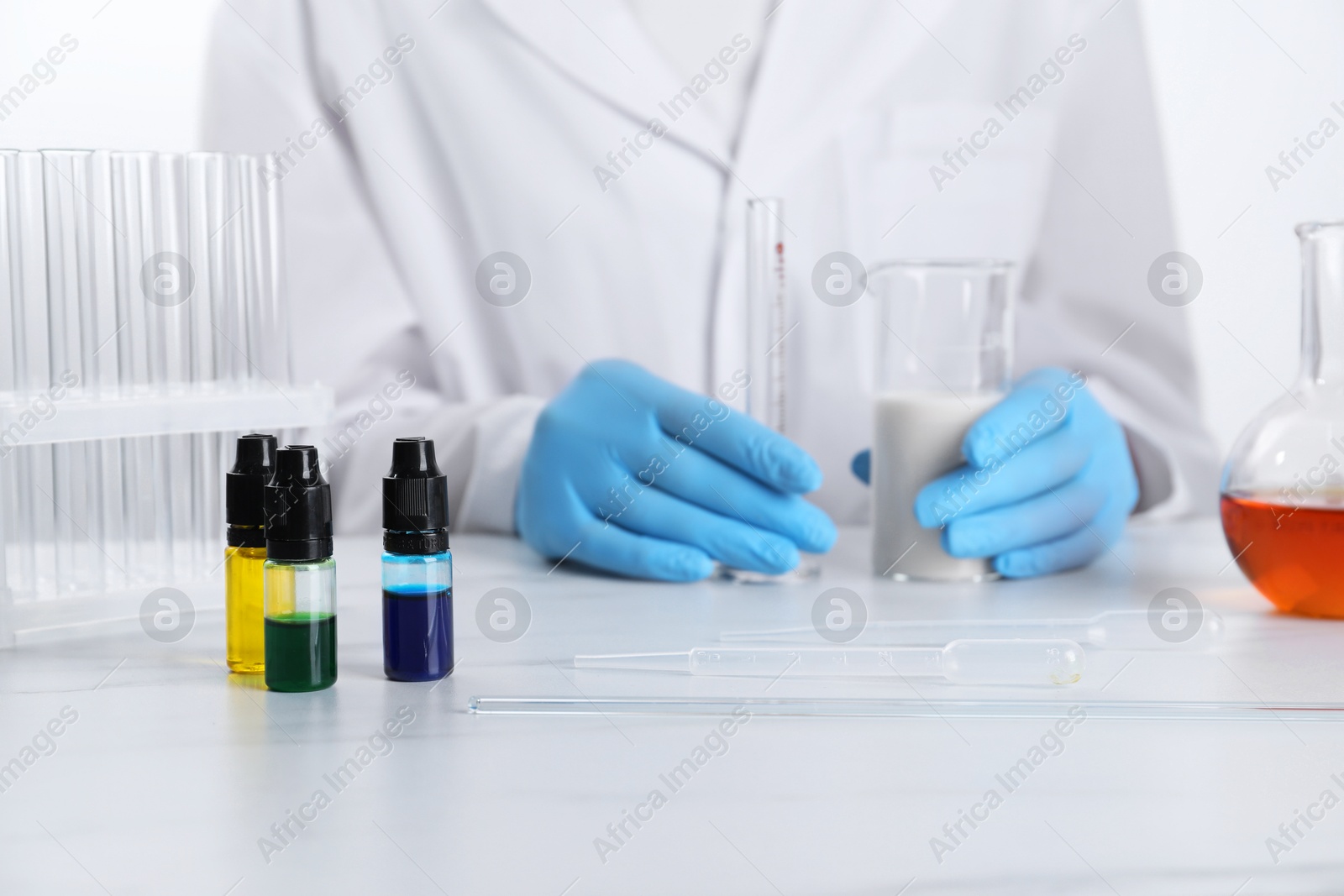 Photo of Laboratory testing. Scientist working with glassware at white marble table, closeup