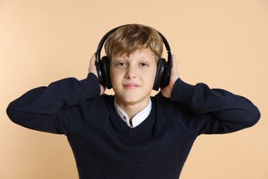 Photo of Portrait of teenage boy in headphones on beige background