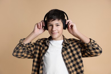 Photo of Portrait of teenage boy in headphones on beige background