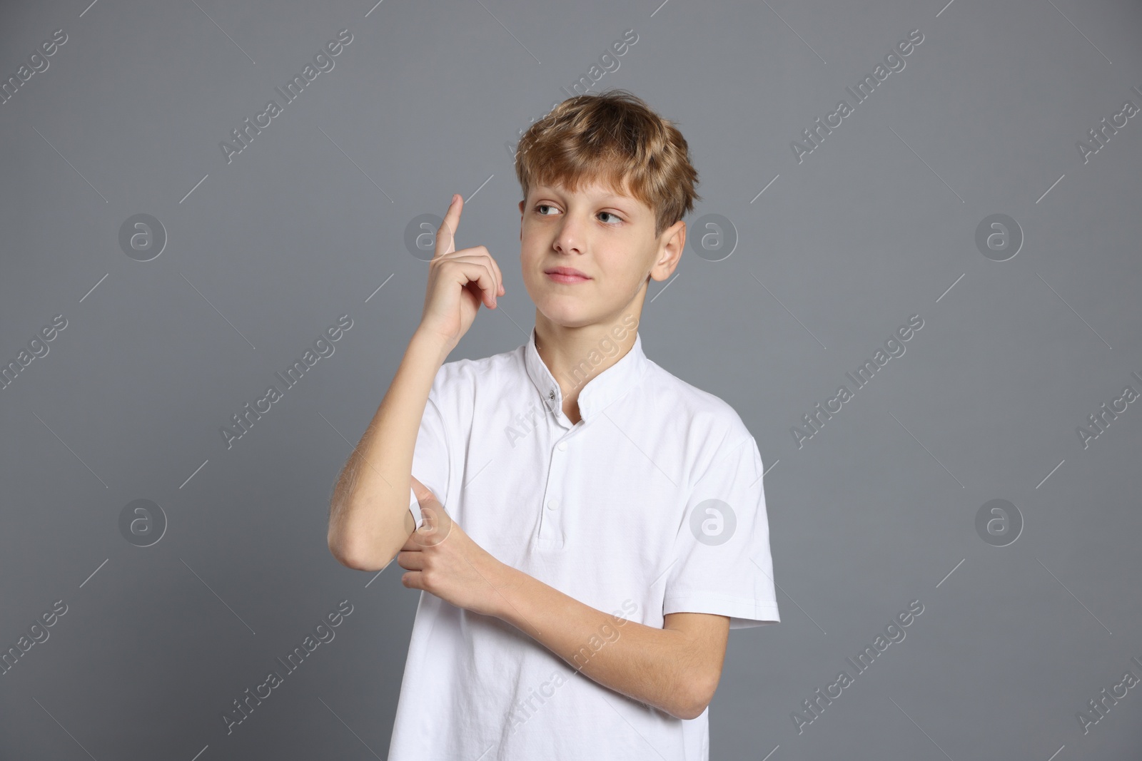 Photo of Portrait of teenage boy on grey background