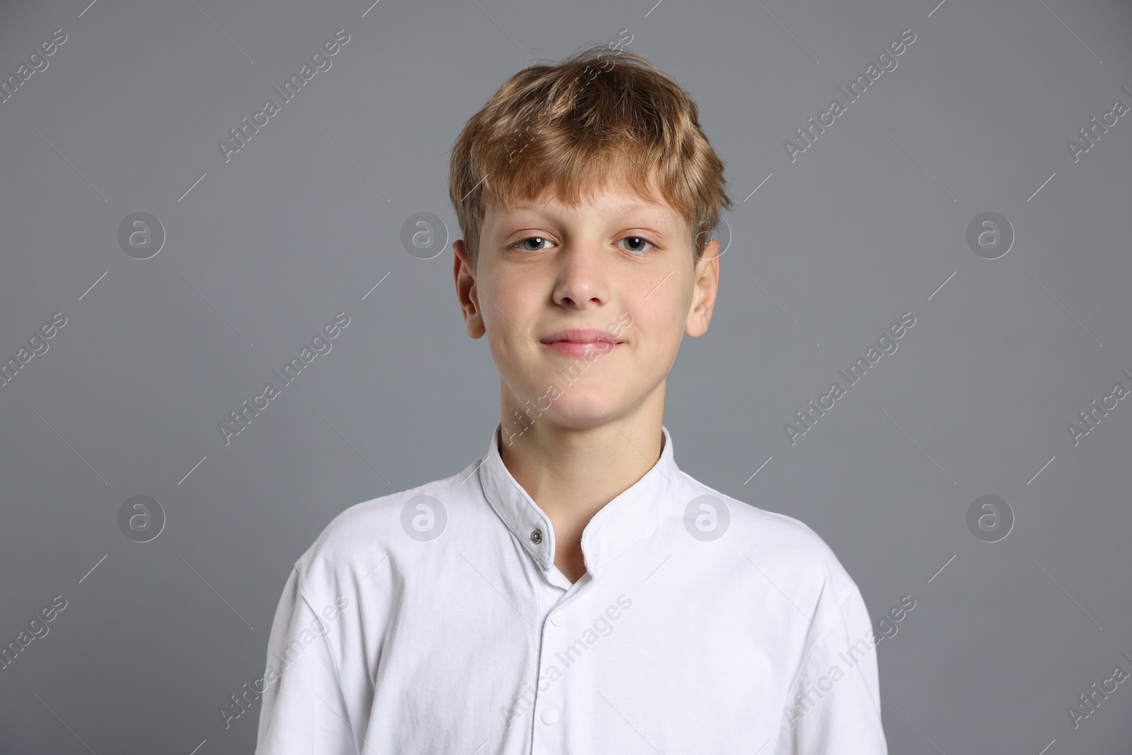 Photo of Portrait of teenage boy on grey background