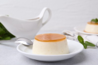 Photo of Tasty pudding with caramel sauce served on white table, closeup