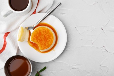 Photo of Tasty pudding with caramel sauce served on white textured table, flat lay. Space for text