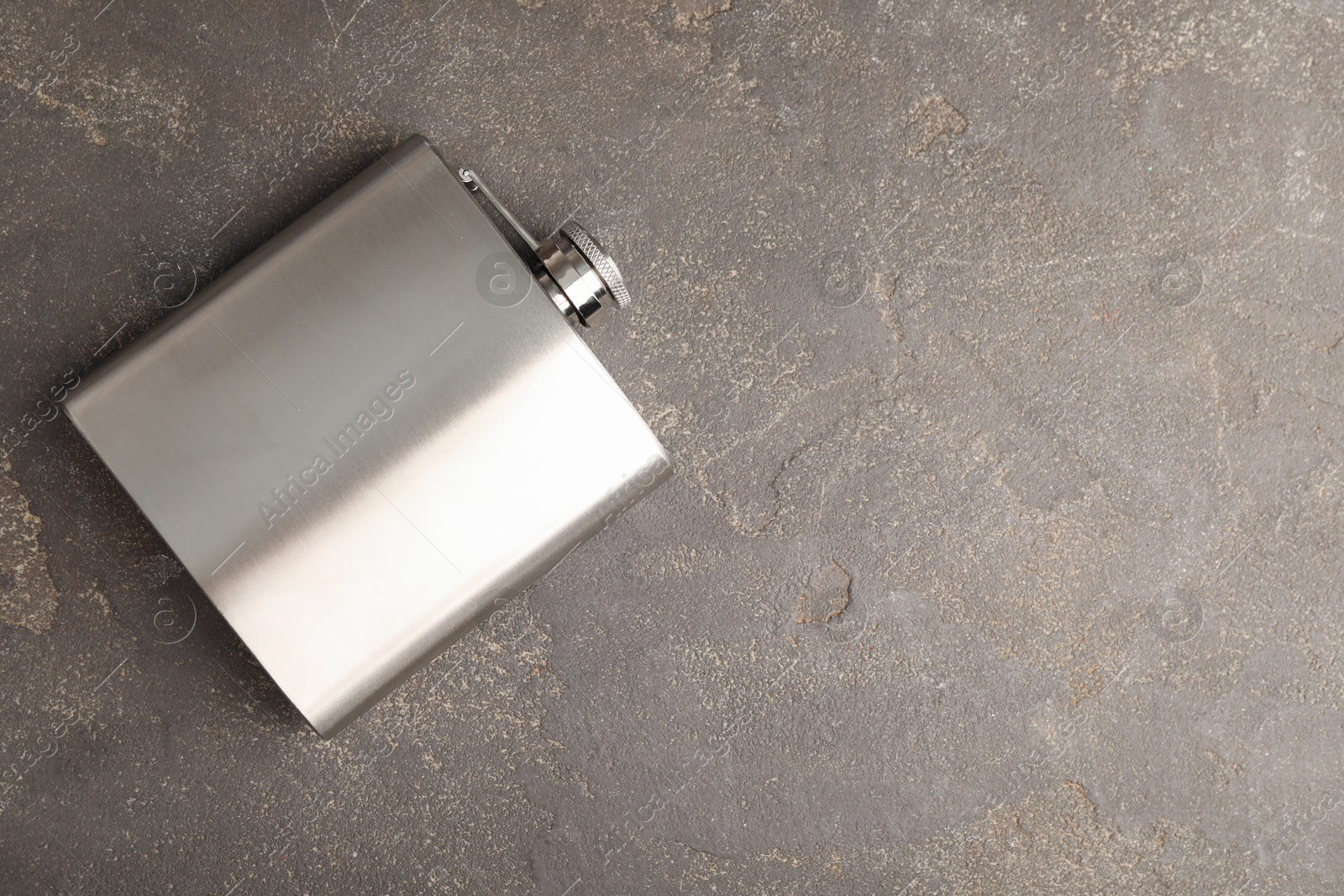 Photo of One hip flask on grey table, top view. Space for text